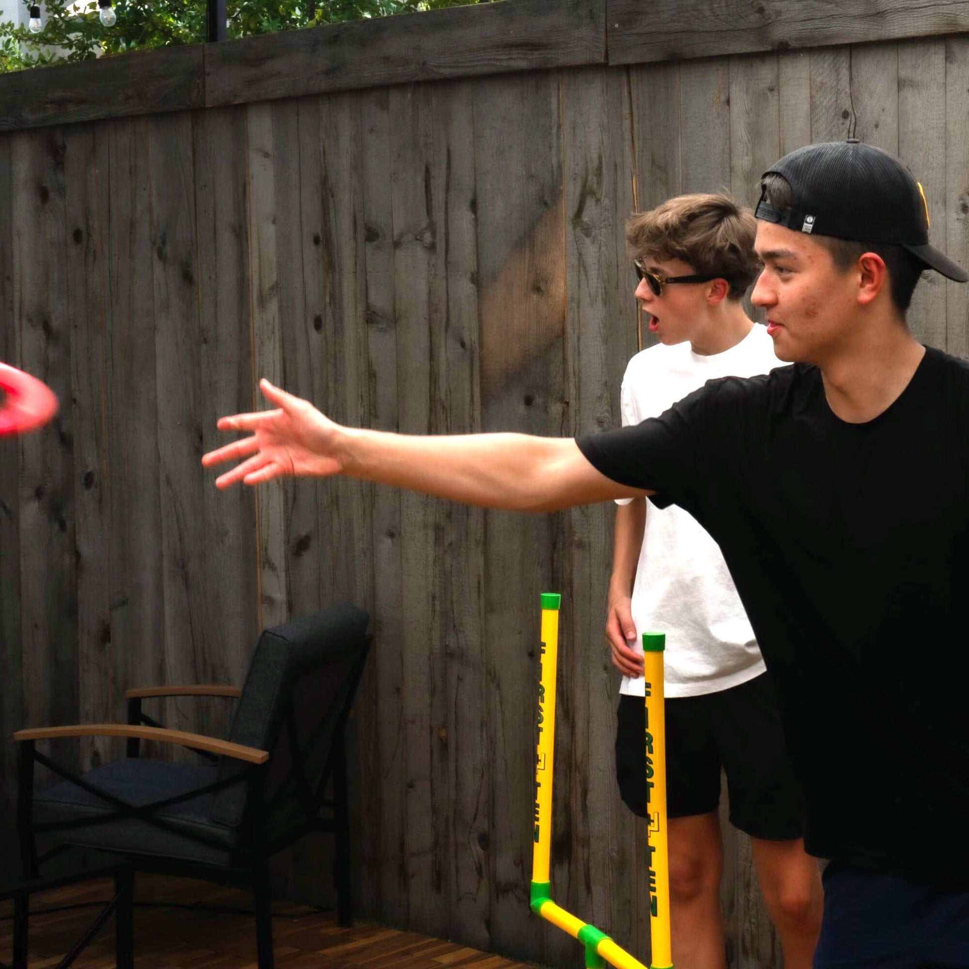 Young guy on the right tossing a red First-N-Ten ring and a second guy looking on in surprise